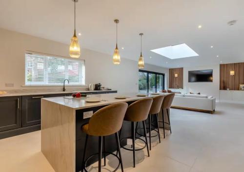 a kitchen with a large island with bar stools at Newly Renovated luxury seaside property with hot tub - near to Cromer & Sheringham in West Runton
