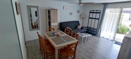 un salon avec une table, des chaises et un canapé dans l'établissement LA ROSE DES VENTS , T3 à SOUSTONS / VIEUX BOUCAU, à Soustons