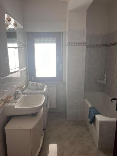 a bathroom with a sink and a toilet and a tub at Benvenue appartamento incantevole in Avezzano