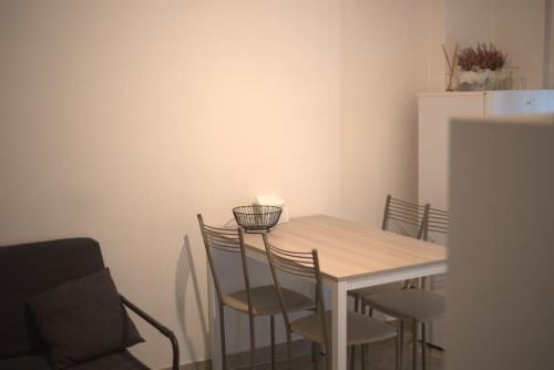 a dining room table with chairs and a white refrigerator at Benvenue appartamento incantevole in Avezzano