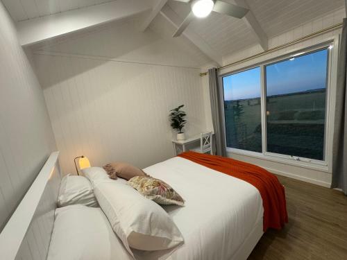 a bedroom with a large bed and a window at Kingdom Cottages in Gulgong