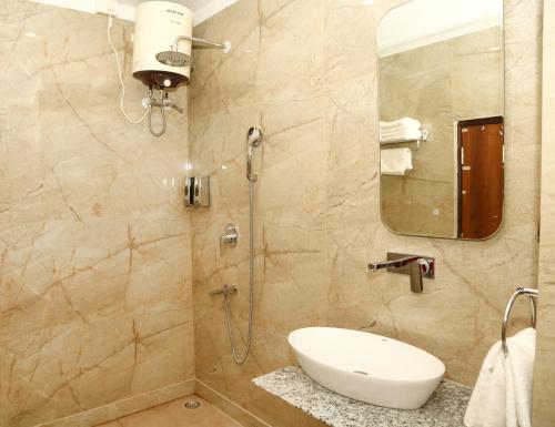 a bathroom with a shower with a sink and a mirror at The Crescent in Udaipur