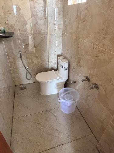 a bathroom with a toilet and a bucket in it at IVY Lemon Green in Bengaluru