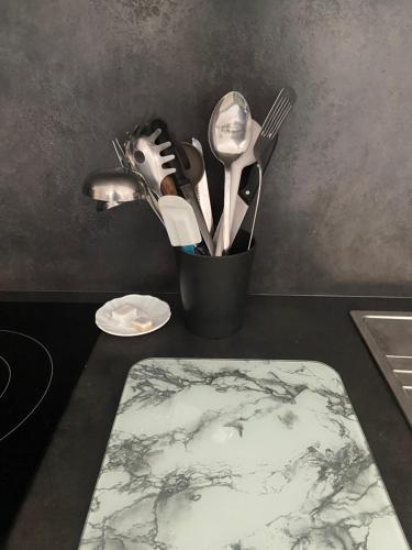 un conteneur d'ustensiles de cuisine assis sur un comptoir dans l'établissement Maison avec jardin proche Paris et Disney, à Pontault-Combault