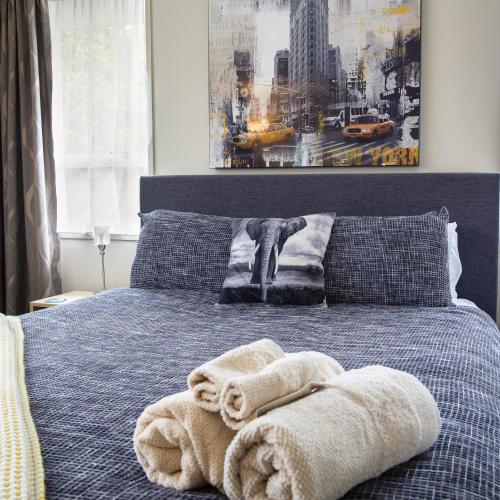 a bedroom with a bed with towels on it at Chic Private Studio 5 mins from Airport and shops in Christchurch