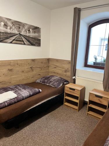 a bedroom with two beds and a window at Penzion Mánes in Krabčice