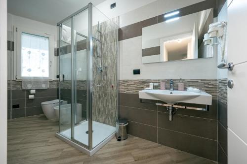 a bathroom with a glass shower and a sink at Milena Suite Apartments in Alghero
