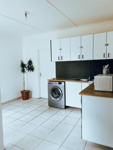 a kitchen with a washer and a washing machine at City Central Self-catering in Windhoek