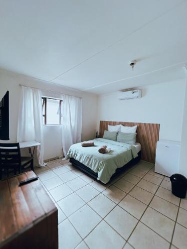 a bedroom with a bed and a desk in it at City Central Self-catering in Windhoek