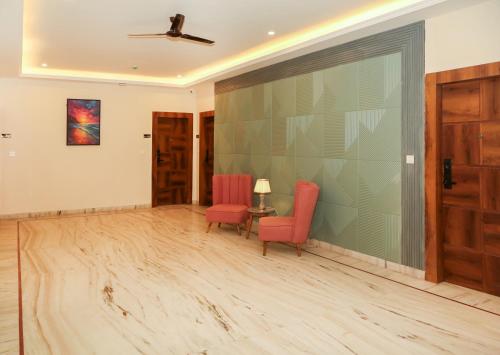 a living room with two chairs and a sliding glass door at The Crescent in Udaipur