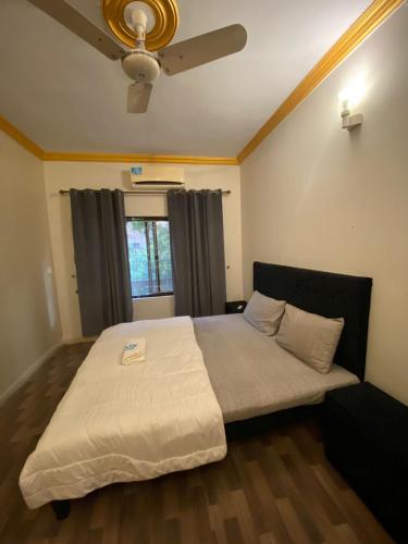 a bedroom with a large bed with a ceiling fan at Durrani Executive - Islamabad F10 in Islamabad