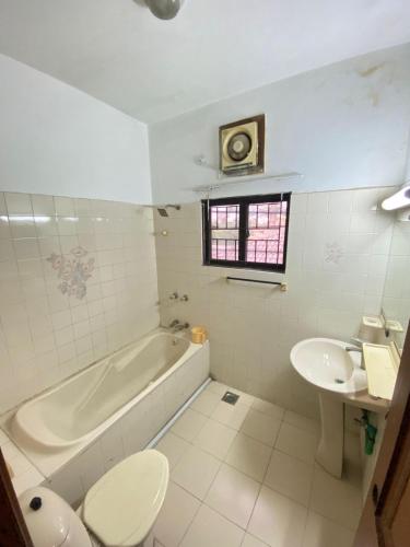 a bathroom with a tub and a toilet and a sink at Durrani Executive - Islamabad F10 in Islamabad