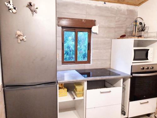 a small kitchen with a refrigerator and a window at Charming House in Irañeta with Fenced Garden in Irañeta