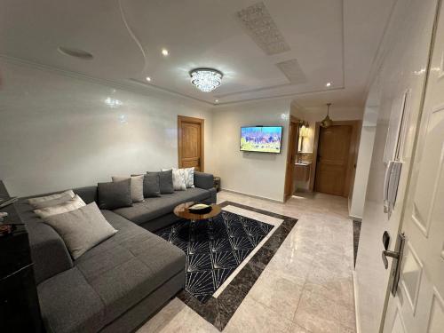 a living room with a couch and a tv at Fez Spacious Stay with Moroccan Artisanal Charm in Fès