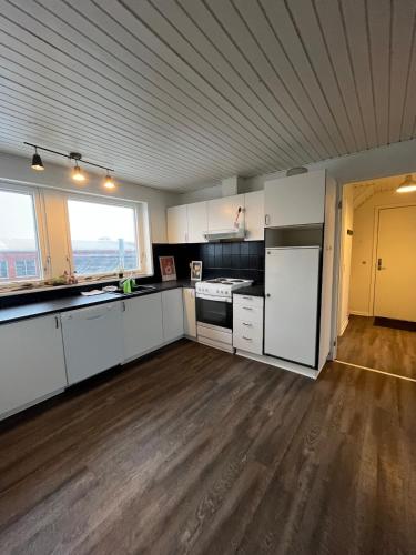 una cocina vacía con armarios blancos y una ventana grande en Perfect space for you and your colleague, en Vinderup