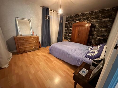 a bedroom with a bed and a dresser and a mirror at Plain pied aux portes de La Rochelle 2chbres in Saint-Xandre
