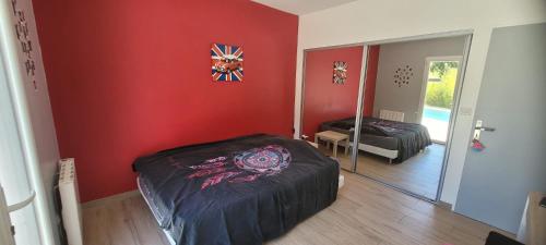 Cette chambre rouge comprend un lit et un miroir. dans l'établissement villa, à Lorgues