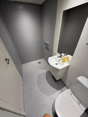 a white bathroom with a sink and a toilet at Folsted - Værelse 204 med eget badeværelse og fri parkering in Bindslev