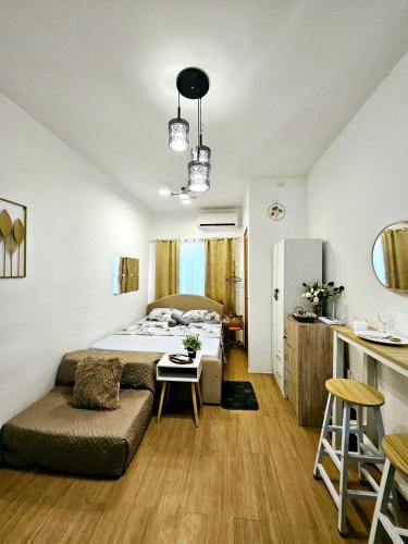 a bedroom with a bed and a couch and a table at Getaway Gem in the City - Ann's Residences in Lapu Lapu City