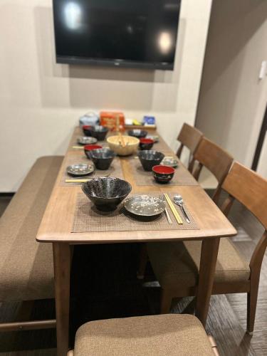 a wooden table with bowls of food on it at 悦然民宿-天下茶屋 in Osaka