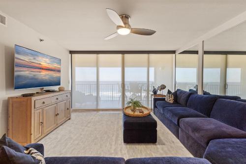 a living room with a blue couch and a tv at Chadham by the Sea 413 in New Smyrna Beach