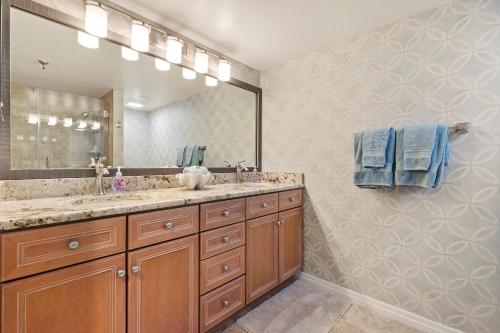 a bathroom with a sink and a large mirror at Chadham by the Sea 413 in New Smyrna Beach