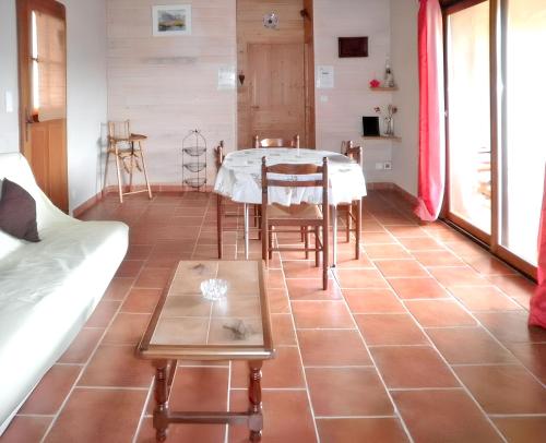une pièce avec une table, des chaises et un canapé dans l'établissement Maison charmante à Molières avec vue sur le lac, à Molières