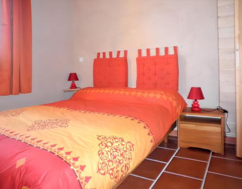 - une chambre dotée d'un lit avec des draps rouges et jaunes dans l'établissement Maison charmante à Molières avec vue sur le lac, à Molières