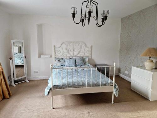 a bedroom with a bed and a chandelier at Large Victorian Townhouse in Buxton