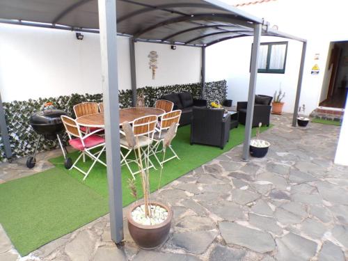a patio with a table and chairs under a tent at Casa V del Pino in Teror