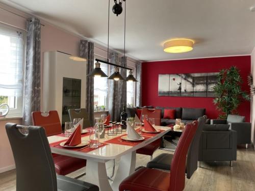 a dining room with a table and red walls at Ferienhaus BellaVita in Walkenried