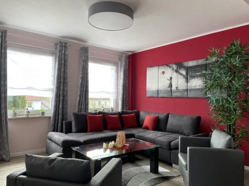 a living room with a couch and a red wall at Ferienhaus BellaVita in Walkenried