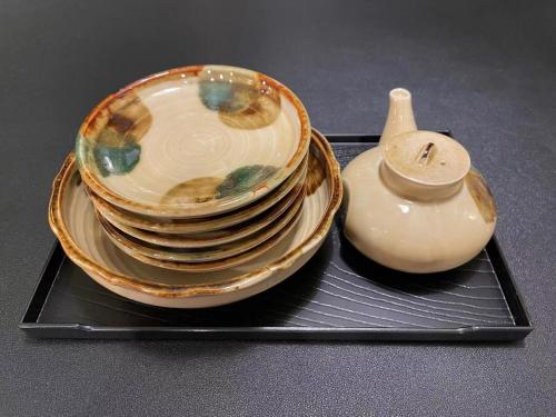 a pile of plates and a vase on a tray at 悦然民宿-天下茶屋 in Osaka