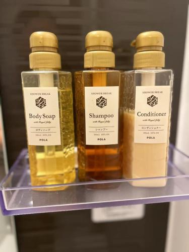 three bottles of baby syrup on a shelf at 悦然民宿-天下茶屋 in Osaka