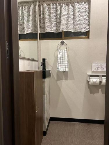 a bathroom with a sink and a mirror and a window at 悦然民宿-天下茶屋 in Osaka