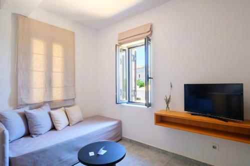 a living room with a couch and a flat screen tv at Margo Beach Hotel in Gythio