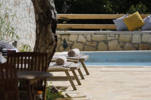 a chair with towels on it next to a pool at Ontas Traditional Apartment In Gavalochori - BY APOKORONAS VILLAS in Gavalochori