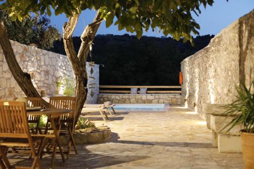 a patio with a table and chairs and a tree at Ontas Traditional Apartment In Gavalochori - BY APOKORONAS VILLAS in Gavalochori