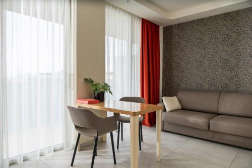 a dining room with a table and a couch at Hotel Aria in Rimini