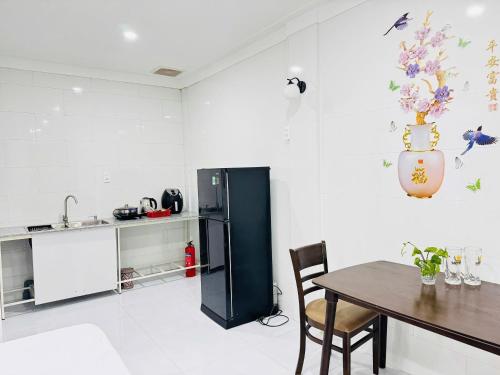 a kitchen with a table and a black refrigerator at Homestay Dương Đông Town in Phu Quoc