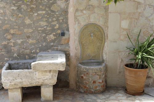a stone sink next to a stone wall with a fountain at Ontas Traditional Apartment In Gavalochori - BY APOKORONAS VILLAS in Gavalochori