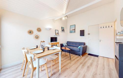 un salon avec une table et un canapé bleu dans l'établissement Pet Friendly Apartment, à Saint-Georges-de-Didonne
