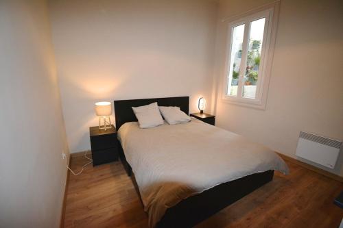 une chambre avec un lit avec deux lampes et une fenêtre dans l'établissement Duguesclin - luxueux T3 dans le centre historique, à Montpellier