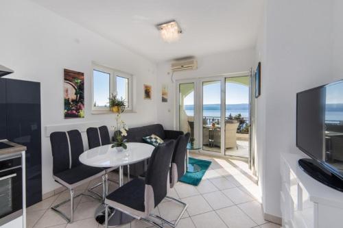 ein Wohnzimmer mit Tisch und Stühlen und einem Fernseher in der Unterkunft Apartment Tafra 2 in Lokva Rogoznica