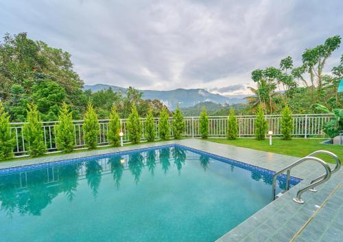 a swimming pool in a yard with a fence at Ice Mist Pool Resort Munnar By VOYE HOMES in Munnar