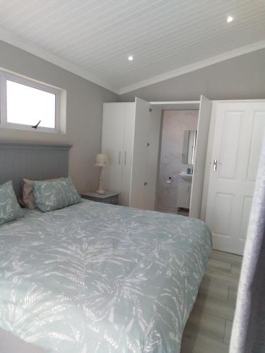 a bedroom with a bed and a window and a bathroom at Marina Cottage in Marina Da Gama