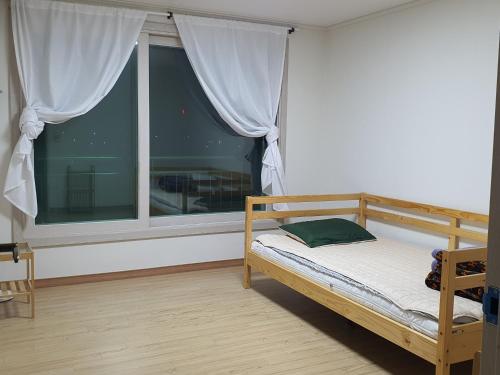 a bedroom with a bed and a large window at Keumho river house in Yeongcheon