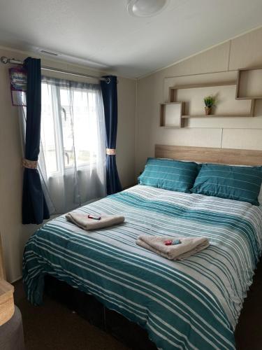 a bedroom with a bed with two towels on it at Tucker’s Retreat in Dymchurch