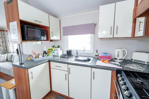 a kitchen with white cabinets and a counter top at Springfield B6 in Brixham