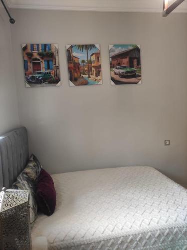 a bed in a room with three pictures on the wall at Mounia Moon in Casablanca